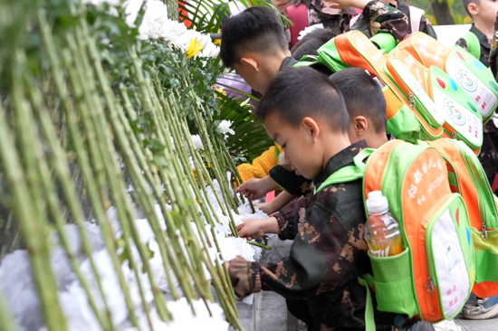 学生在纪念碑前敬献鲜花
