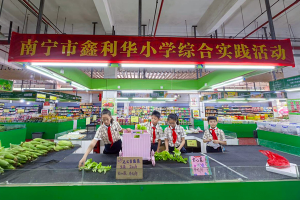 四(1)班少先队员代表到鑫利华市场做种植义卖前期准备。马川子摄