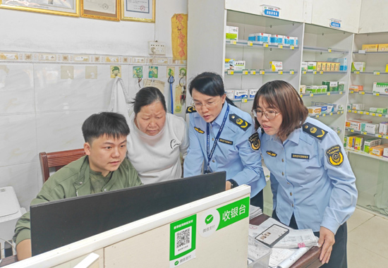 执法人员查看药品购销情况。大化县市场监督管理局供图