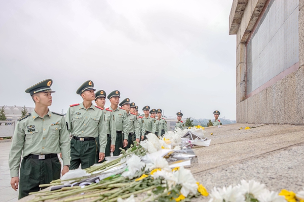武警官兵在隔离烈士纪念碑前绕行瞻仰。