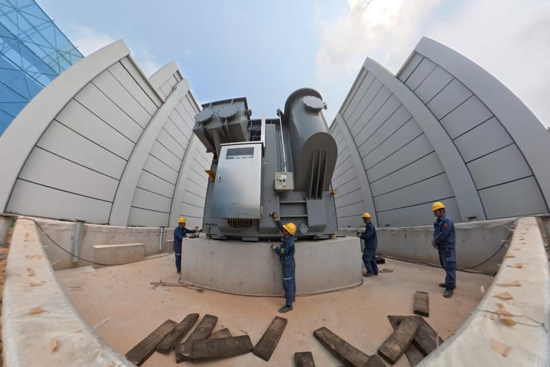 4月8日，在500千伏龙潭（玉林三）输变电工程施工现场，电力人员正将500千伏主变压器就位。梁磊摄 