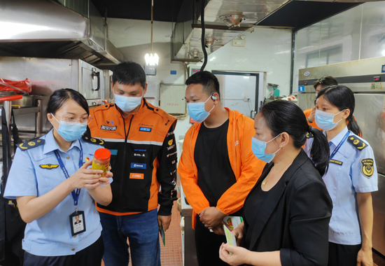 执法人员联合骑手们开展后厨食品安全检查。