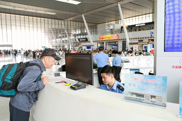 南宁北站客运员解答旅客问讯。蒲子怡摄