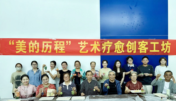 活动参与者们手持制皂成果与项目成员合影留念。北海艺术设计学院供图