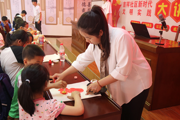 志愿者在易地搬迁社区带留守儿童制作手工拓印。广西幼师供图