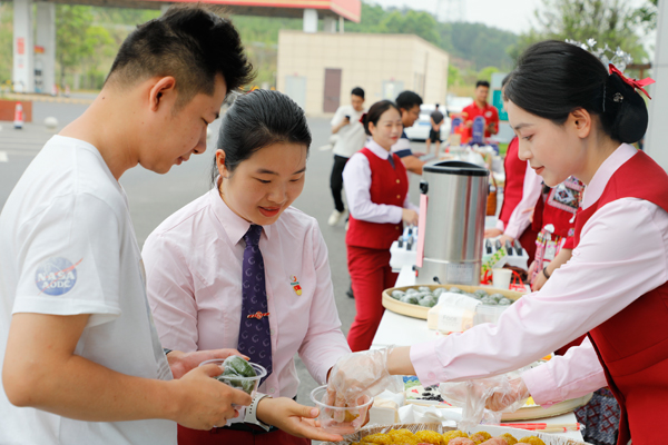 与司乘品尝民族美食。丘雅萍摄
