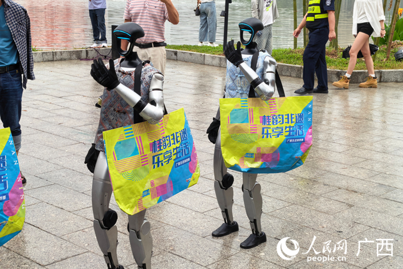 AI机器人和市民游客招手互动。人民网 庞惠文摄