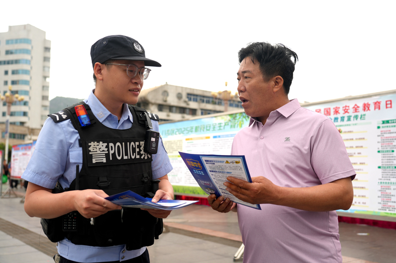 贺州市公安局反恐怖特巡警支队民警向群众发放反恐防暴宣传单。