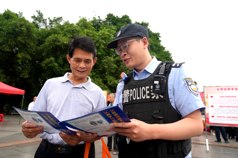 贺州市公安局反恐怖特巡警支队民警向群众发放反恐防暴宣传单。
