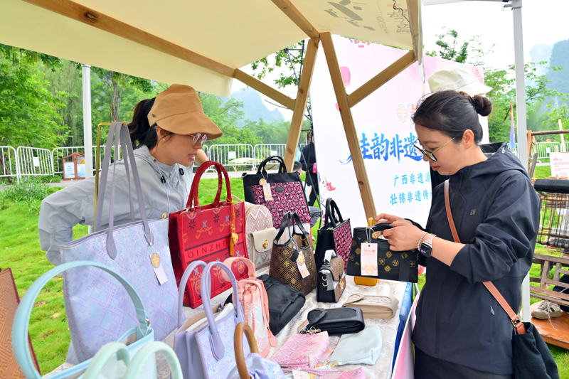 壮锦包包吸引游客驻足观赏、选购。