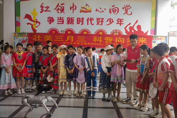 科普大篷车进校园，智能机器狗与身着民族服饰的学生趣味互动。雷必雨摄
