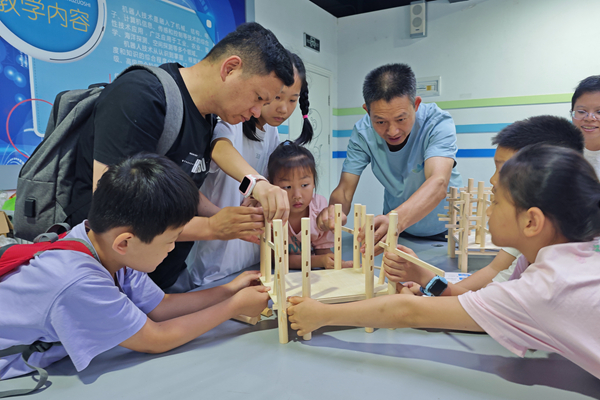 “悬柱的力学密码”活动上，孩子们动手搭建真武阁模型，在实验中学习榫卯结构与力学平衡，探索古建筑“四柱悬空”的科学奥秘（王靖山 摄）