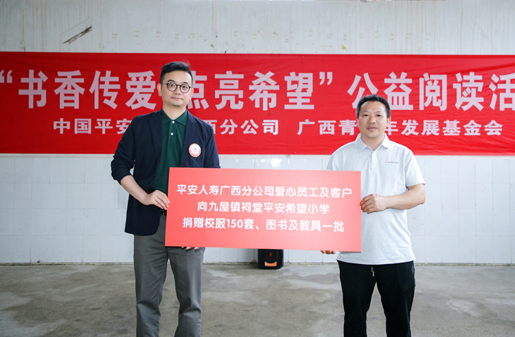 平安人寿广西分公司副总经理柯晓明（左）作为代表向灵川县九屋镇祠堂平安希望小学捐赠150套校服和一批图书及教具。平安人寿广西分公司供图