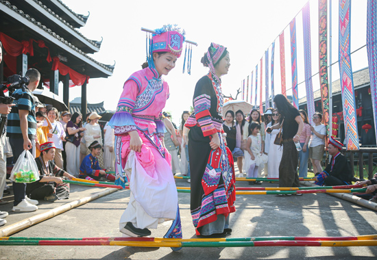 4月18日，世外桃源景区身着民族服饰的游客跳起了竹竿舞。