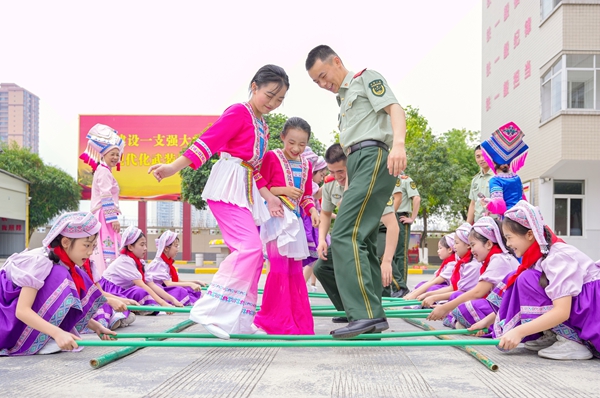 官兵与驻地学生共跳竹竿舞。赖治华摄