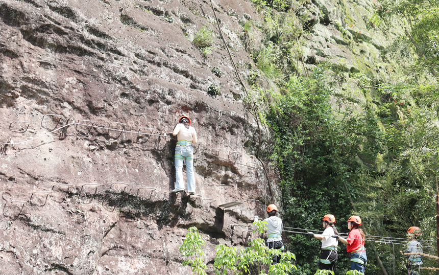 徒步爱好者们漫步于丹霞山水之间，尽享春日户外乐趣。