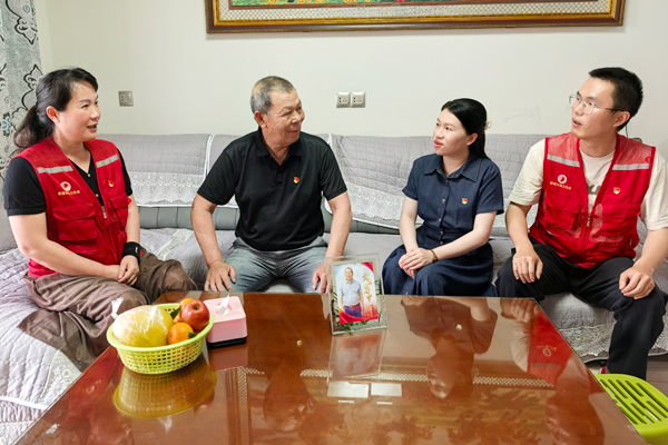 社区工作人员与老党员促膝谈心。