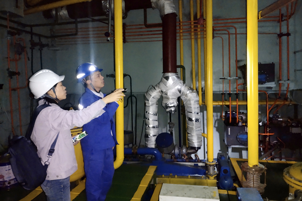团队教师与企业工程师在平陆运河示范船建造现场进行技术交流。学校供图