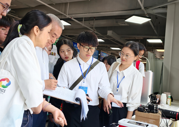 团队向专家评委介绍《充电桩AI智能调度与错峰充放电系统》原型机。广西交通职业技术学院供图