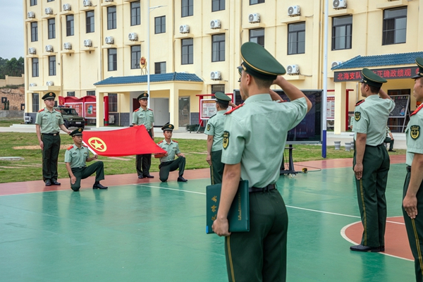 武警官兵面向团旗宣誓。