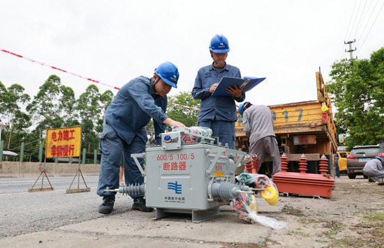 5月2日，南方电网广西新电力集团容县供电公司城南供电所员工正在10千伏木井线进行自动化开关安装。伍波丽摄
