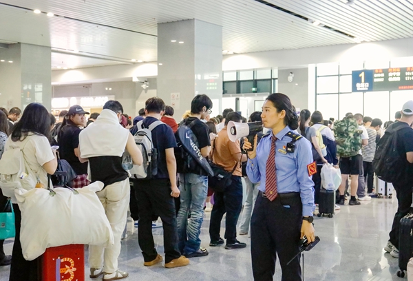 桂林車站工作人員在候車室引導旅客有序排隊檢票。鄭長賢攝