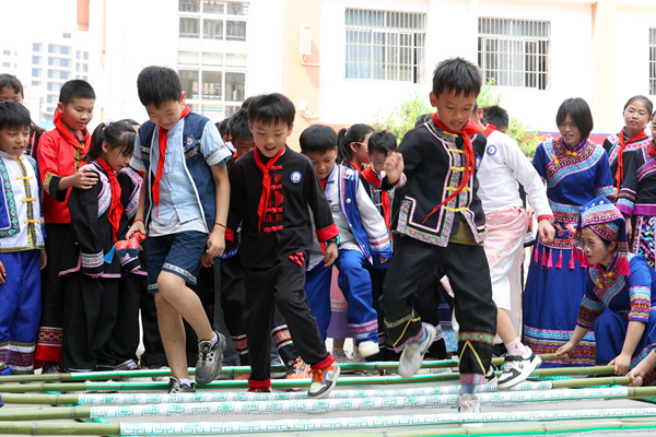 那坡县深龙小学生在体验竹竿舞。莫军摄