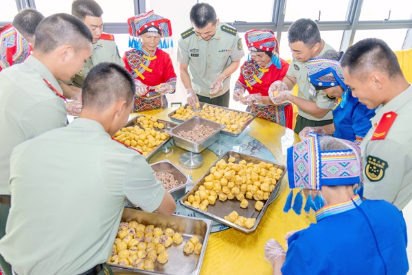 武警官兵與駐地少數民族群眾制作特色豆腐釀。
