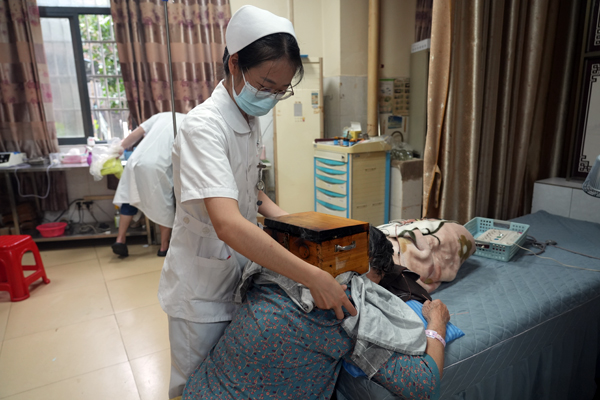 彭荣珍在为患者进行中医理疗。廖法丽摄