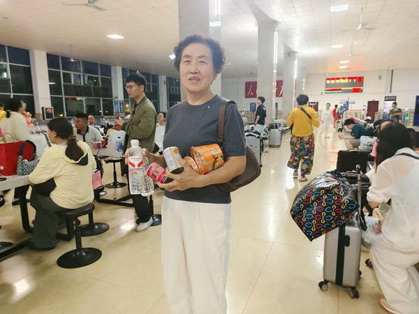 金城江站工作人员为滞留旅客提供应急食品和饮用水。王学武摄