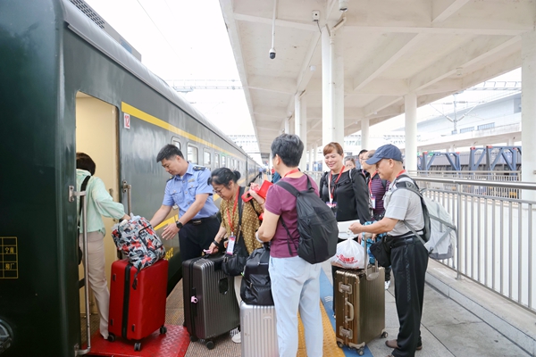 乘务员协助旅客搬运行李。谭媛元摄