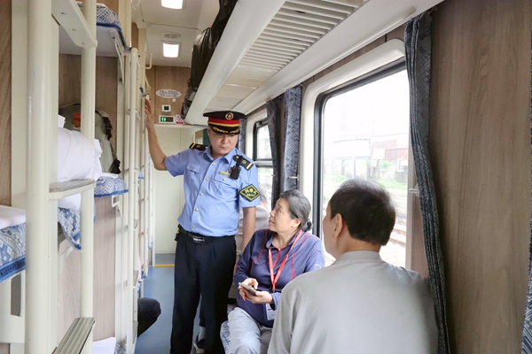 列车长耐心地叮嘱旅客乘车安全注意事项。谭媛元摄