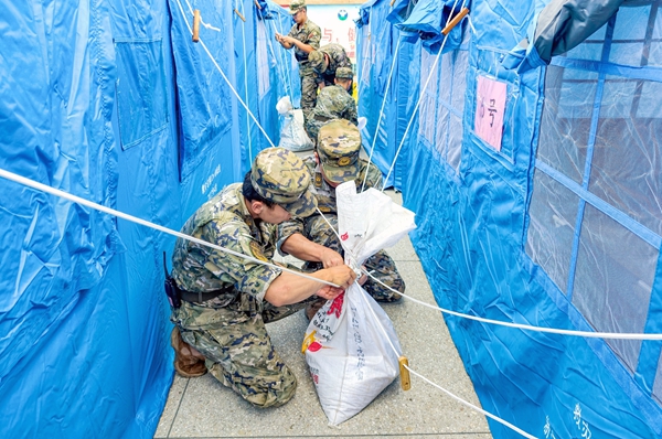 武警官兵加固应急救灾帐篷。李晓鹏摄