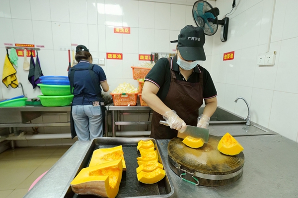 食堂工作人员为减脂餐备菜。韦刚摄