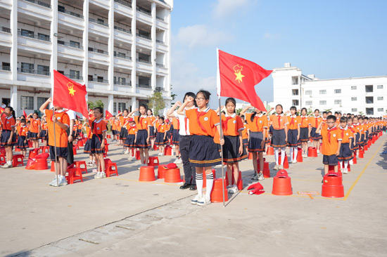 新队员面向队旗高举右拳庄严宣誓，誓言铿锵有力。博白县委宣传部供图