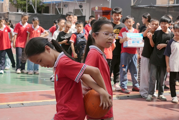 圖為西林縣八達鎮第一小學游園活動項目背靠運球。熊英秀攝