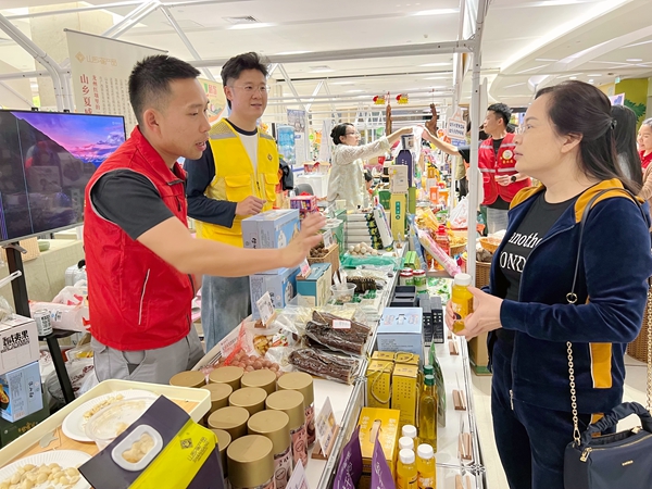 3.图为民治村第一书记潘东钦带着农产品参加展销会.jpg