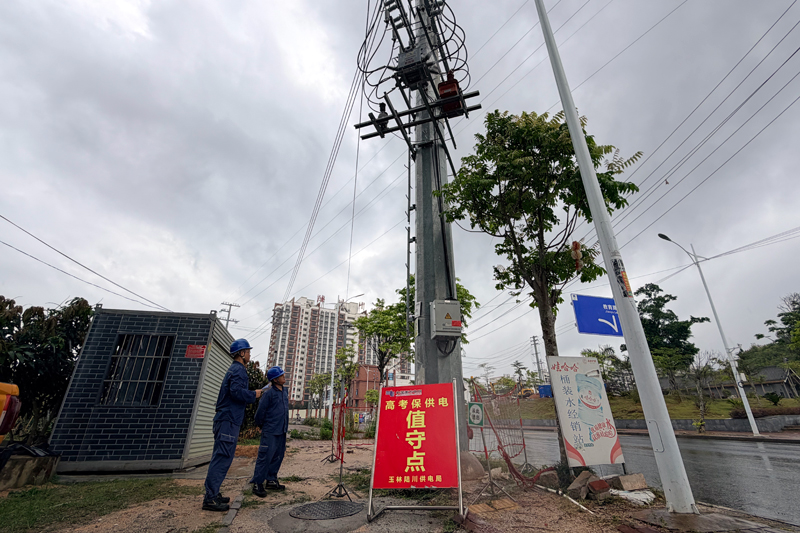 南方电网广西玉林陆川供电局工作人员在陆川中学东校区外的教育I02开关进行保供电值守及设备监测。温靖铭摄