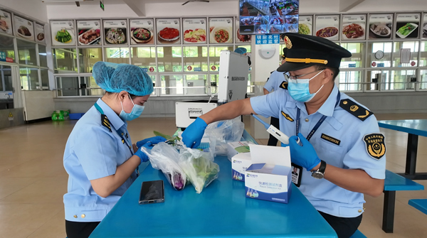 港口区市场监督管理局工作人员在对菜品进行抽样检查。钟云需摄