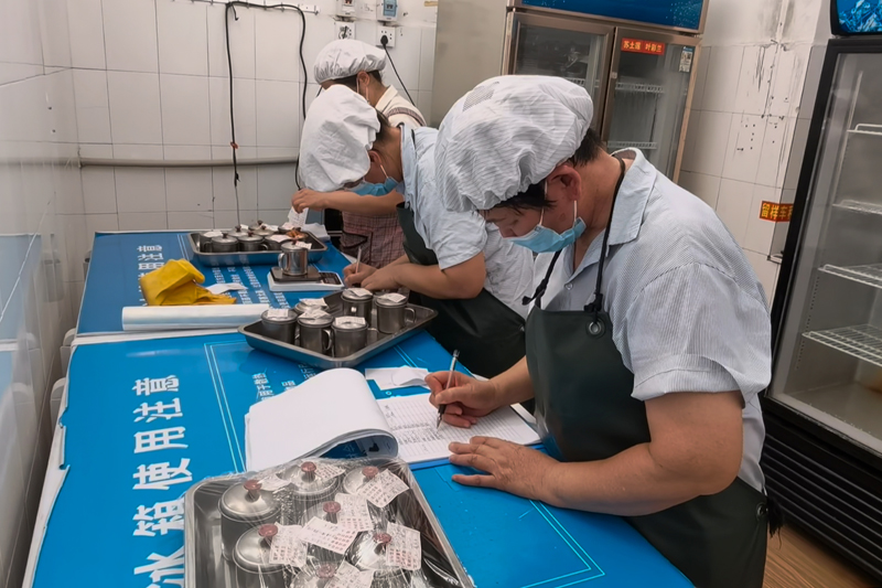 在贺州第四高级中学,食堂人员正在对食品进行留样保存。八步区市场监督管理局供图