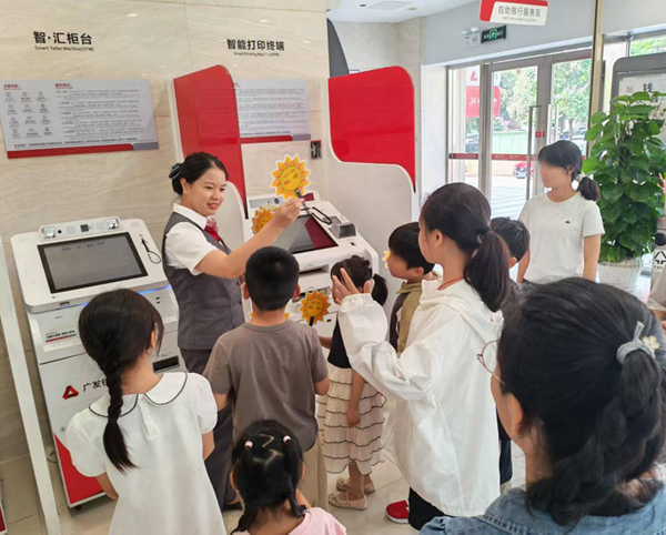广发银行南宁分行工作人员向孩子们介绍智能机具功能。庞国翰摄