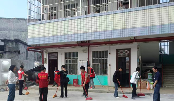 图为志愿服务队为敬老院的老人们打扫庭院