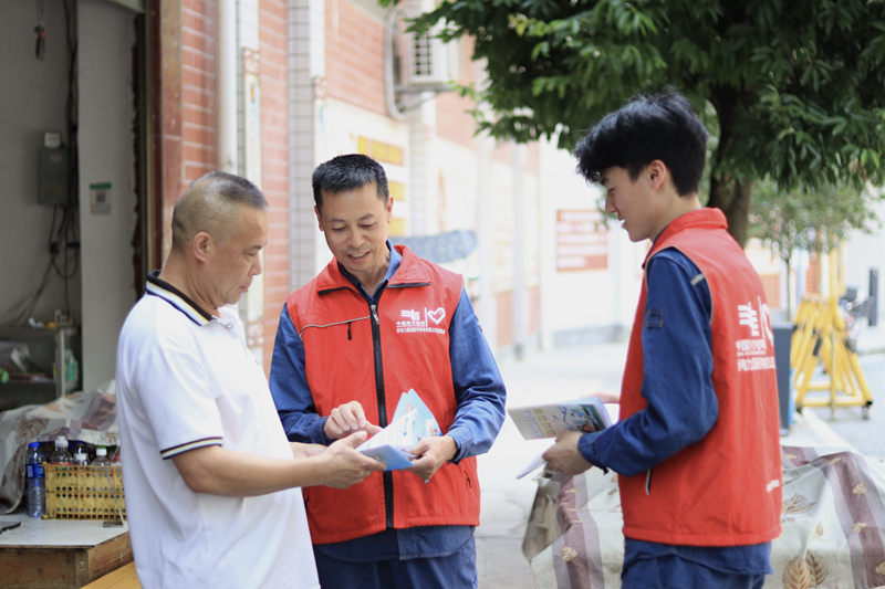 志愿者向群众发放安全用电宣传册。谢宜荻摄