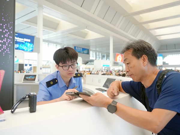 南宁东站客运员解答旅客问询。冯泓珲摄