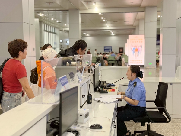 桂林北站服务台工作人员为旅客办理车票改签业务。李洪锐摄