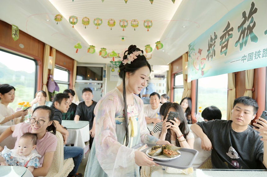 Z6次列车乘务员为旅客送上端午粽子。曹烁摄