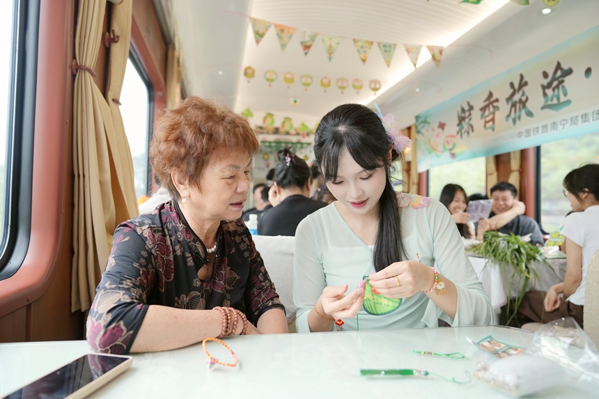 Z6次列车乘务员与旅客共同制作香囊。曹烁摄