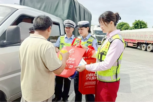 志愿者向司乘发放安全礼包。