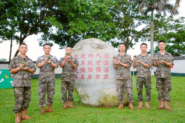 官兵在文化石前展示包好的粽子。劉俊暉攝