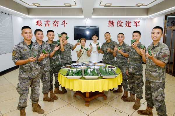 官兵和駐地家屬一起展示包好的粽子。劉俊暉攝